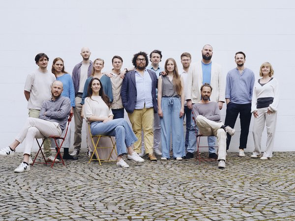 Eine Gruppe fröhlicher Menschen steht und sitzt zusammen